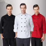 Three chefs wearing black, white, and red polycotton long sleeve chef's jackets with mandarin collars and double-breasted designs.