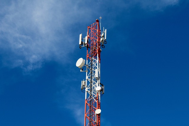 A Guyed Tower installed against a clear blue sky, equipped with multiple antennas and communication equipment.